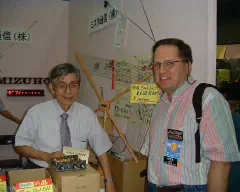 With JA1AMH, Takada-san of Mizuho, who is standing behind their new small KX-QRP wide-range antenna tuner. (Thanks to JA1CQT for the photo.)